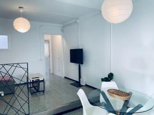 uma sala de estar com uma mesa de vidro e cadeiras brancas em Hauzify I Apartament Monlema em Sant Feliu de Guíxols