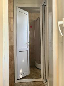 a sliding glass door in a bathroom with a shower at Hostel FORREST in Kutaisi