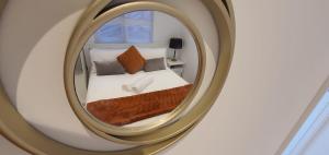 a mirror reflecting a bed in a bedroom at Deluxe Pad with Sauna in Low Street