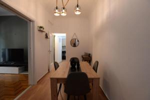 ein Esszimmer mit einem Tisch, Stühlen und einem TV in der Unterkunft Minimal apartment in koukaki in Athen