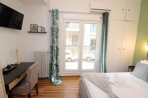 Schlafzimmer mit einem Bett, einem Schreibtisch und einem Fenster in der Unterkunft Minimal apartment in koukaki in Athen