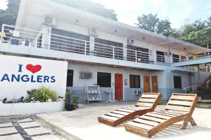 two lounge chairs in front of a building at Angler's Hub & Resort in Oslob