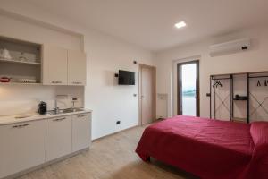 een slaapkamer met een rood bed en een keuken bij Green Residence Villa Assunta in Moscufo