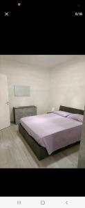1 dormitorio con 1 cama grande con sábanas moradas en Home in City/Airport, en Bolonia