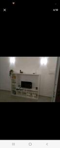 - un salon avec une télévision sur un mur blanc dans l'établissement Home in City/Airport, à Bologne