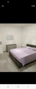 a bedroom with a large bed with purple sheets at Home in City/Airport in Bologna