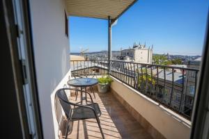a balcony with a table and chairs and a view at Beaumonde Hotel Tbilisi in Tbilisi City