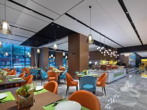 un allestimento di un ristorante con tavoli e sedie di Hampton by Hilton Shenzhen Bao'an Airport a Shenzhen