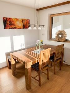 comedor con mesa de madera y sillas en Kathrins Ferienwohnung en Breitenbach am Inn