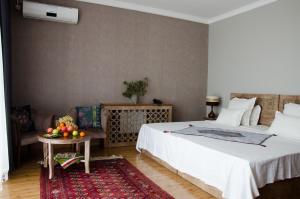 a bedroom with a bed and a table with fruit on it at Hotel Jipek Joli in Nukus