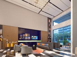 un vestíbulo con sofás y una chimenea en un edificio en Hampton by Hilton Shenzhen Bao'an Airport, en Shenzhen