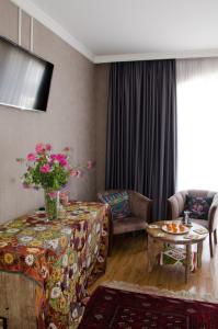 a living room with a couch and a table with flowers on it at Hotel Jipek Joli in Nukus