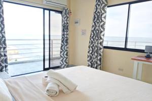 a bedroom with a bed with a view of the ocean at Angler's Hub & Resort in Oslob