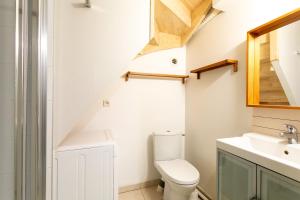 ein Bad mit einem WC und einem Waschbecken in der Unterkunft Logement Coquelicot - 6 personnes in Hillion