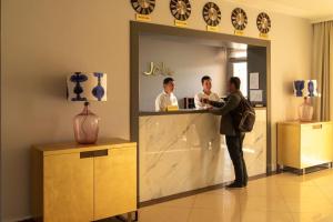 two men standing at a counter in a store at Hotel Jipek Joli in Nukus