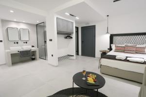 a bedroom with a bed and a table and a bathroom at Yianna Hotel in Skala