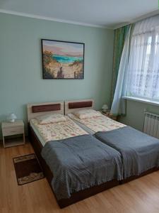 1 dormitorio con 1 cama y una pintura en la pared en LATARNIK, en Władysławowo