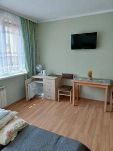 a bedroom with a desk and a desk with a television at LATARNIK in Władysławowo
