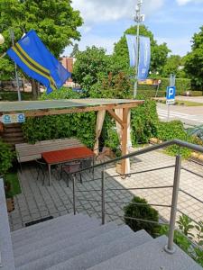 a patio with a picnic table and a blue umbrella at LATARNIK in Władysławowo