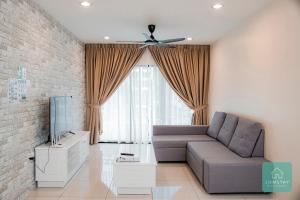 a living room with a couch and a tv at Jomstay Manhattan Suites Ipoh Water Park Homestay in Ipoh