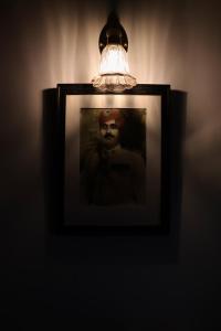 a picture in a frame with a light on a wall at Kishan Palace-A heritage Hotel in Bikaner