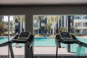 怡保的住宿－Jomstay Manhattan Suites Ipoh Water Park Homestay，健身房享有游泳池的景致,设有2个跑步机