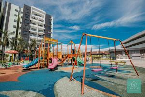 - une aire de jeux avec toboggan et balançoires dans l'établissement Jomstay Manhattan Suites Ipoh Water Park Homestay, à Ipoh