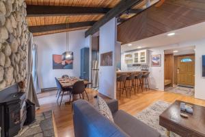 a living room and dining room with a stone wall at #525 Walk to Golf Course, Midtown, Stunning Condo in Mammoth Lakes