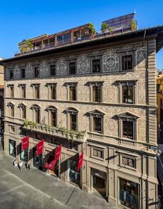 ein Gebäude mit roten Flaggen davor in der Unterkunft Hotel Calimala in Florenz