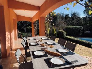 a long table on a patio with chairs at Villa Les Cyprés in Flayosc