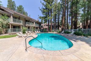 een zwembad met stoelen en een gebouw bij #338 - Naturally Sunlit Condo with Pool, Jacuzzi, Sauna, & Game Room in Mammoth Lakes