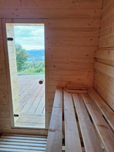 una sauna con ventana y suelo de madera en Domek Muflon w Górach Sowich, en Jugów