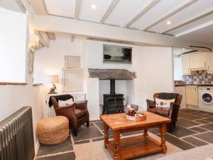 uma sala de estar com uma mesa e um fogão a lenha em Orchard Cottage em Windermere