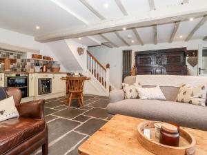 uma sala de estar com um sofá e uma mesa em Orchard Cottage em Windermere
