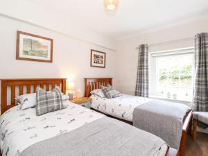 um quarto com 2 camas e uma janela em Orchard Cottage em Windermere