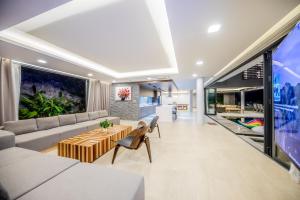 芽莊的住宿－Nha Trang Oceanfront Luxury Villa Anh Nguyen，客厅配有沙发和桌子