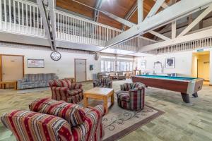 a living room with a pool table and chairs at #359 - Mountain Condo, Walk to Shops with Pool, Spa, & Game Room in Mammoth Lakes