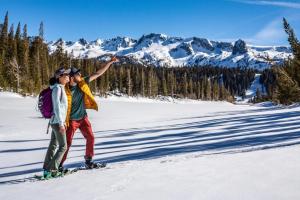 two people standing on skis in the snow at #359 - Mountain Condo, Walk to Shops with Pool, Spa, & Game Room in Mammoth Lakes