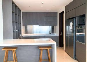 a kitchen with a white counter and two bar stools at Lux & Spacious 3BR in Central Jakarta in Jakarta