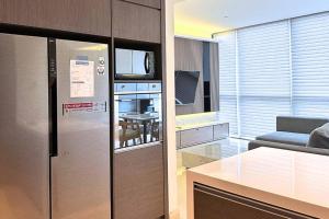 a kitchen and living room with a stainless steel refrigerator at Lux & Spacious 3BR in Central Jakarta in Jakarta