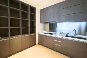 a kitchen with dark brown cabinets and a sink at Lux & Spacious 3BR in Central Jakarta in Jakarta