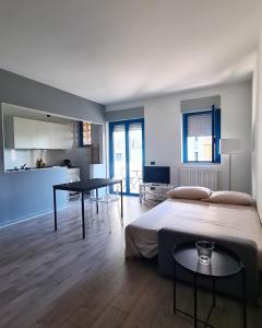 a bedroom with a bed and a table and a kitchen at Casa Mistral in Bari
