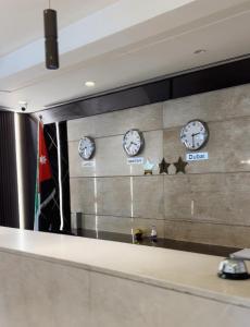 a mirror in a room with clocks on the wall at The Seventh Star Hotel Suites in Amman