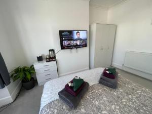 a bedroom with a bed with a tv on the wall at Double Bedroom with TV in Sudbury Hill Wembley - 10 mins from Wembley Stadium in Harrow on the Hill