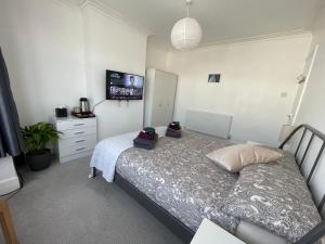 Giường trong phòng chung tại Double Bedroom with TV in Sudbury Hill Wembley - 10 mins from Wembley Stadium