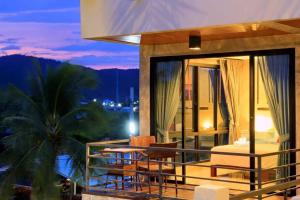 Casa con balcón con mesa y sillas en Windy Seaview Resort, en Chao Lao Beach