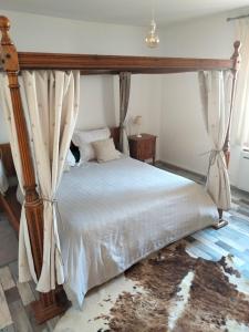 1 dormitorio con 1 cama con dosel en La Petite Auberge 
