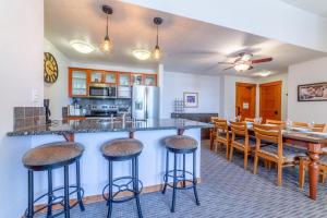 a kitchen and dining room with a bar and stools at #550 Village, Walk to Gondola 3BD, 3BATH with Spa in Mammoth Lakes