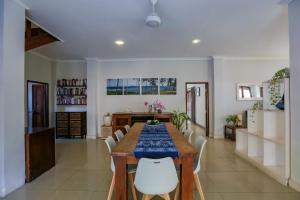 a dining room with a wooden table and white chairs at 3 Bedroom Private House - Tir Na Nog in Gili Trawangan