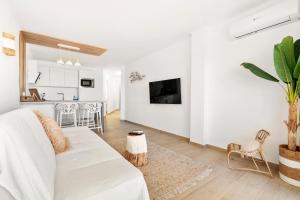 ein weißes Wohnzimmer mit einer weißen Couch und einer Küche in der Unterkunft Apartamento WELCS EMP - 101 con vistas al Mar in Empuriabrava